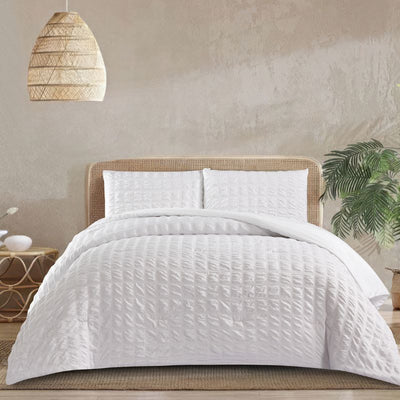 A clean modern bedroom highlights the Morgan and Reid Whispers of White Comforter Set with matching pillowcases, rattan...