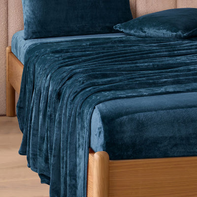 A modern bedroom with a beige upholstered bed and cream bedding exudes winter comfort, enhanced by the Morgan and Reid Winter Microplush Sheet Sets ultra-soft fabric, neutral decor, dried flowers, and light wood floors.