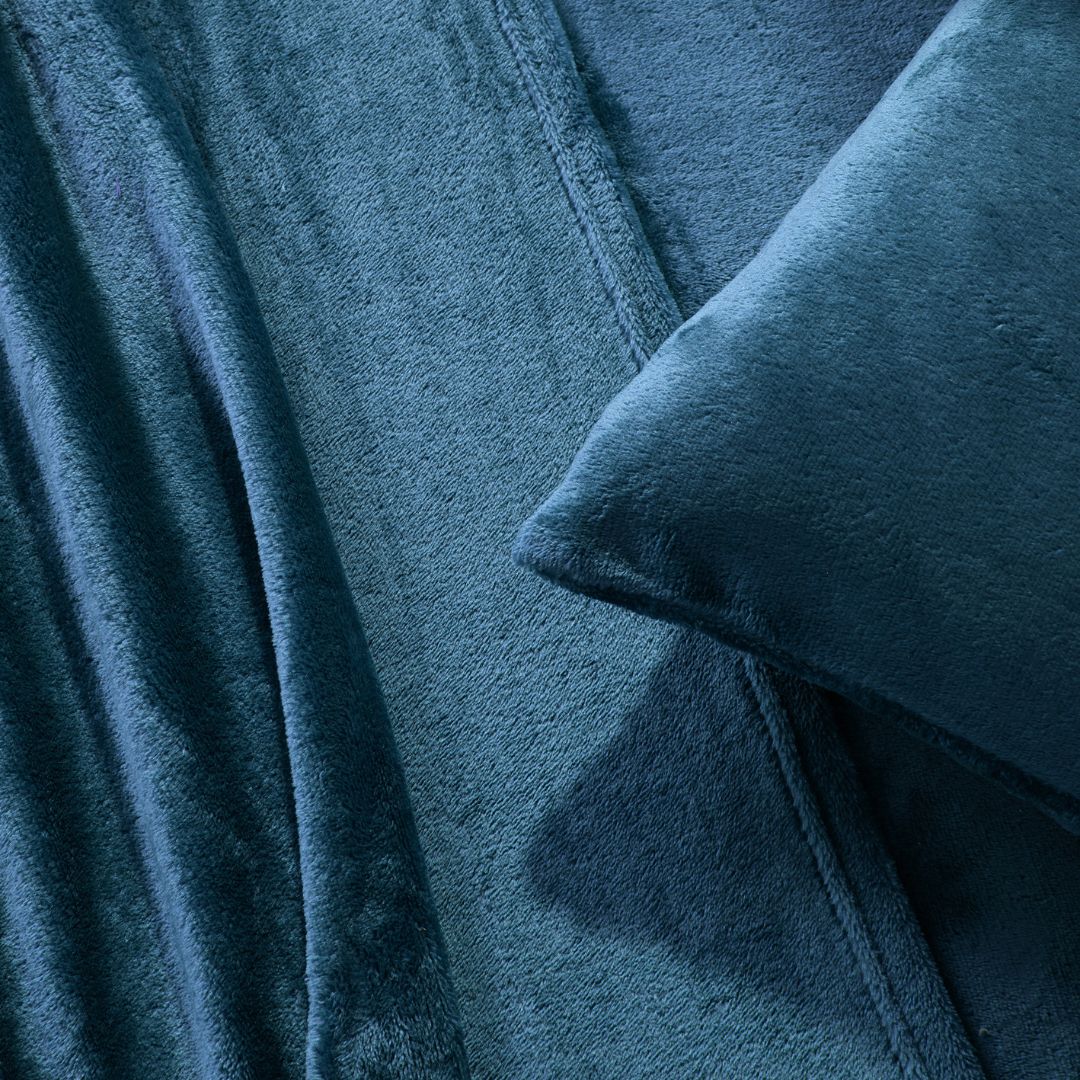 A modern bedroom with a beige upholstered bed and cream bedding exudes winter comfort, enhanced by the Morgan and Reid Winter Microplush Sheet Sets ultra-soft fabric, neutral decor, dried flowers, and light wood floors.