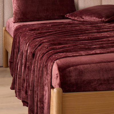 A modern bedroom with a beige upholstered bed and cream bedding exudes winter comfort, enhanced by the Morgan and Reid Winter Microplush Sheet Sets ultra-soft fabric, neutral decor, dried flowers, and light wood floors.