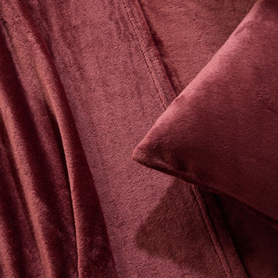 A modern bedroom with a beige upholstered bed and cream bedding exudes winter comfort, enhanced by the Morgan and Reid Winter Microplush Sheet Sets ultra-soft fabric, neutral decor, dried flowers, and light wood floors.