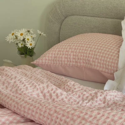 Close up spanning video of a pink checkered comforter.