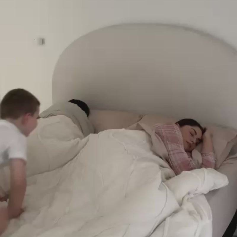 Video of a couple in bed with their child jumping in and enjoying a moment in their cooling comforter.