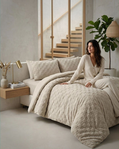 Lifestyle shot of Sand Checkered Snuggle Fleece Comforter Set on bed with woman in neutral bedroom setting