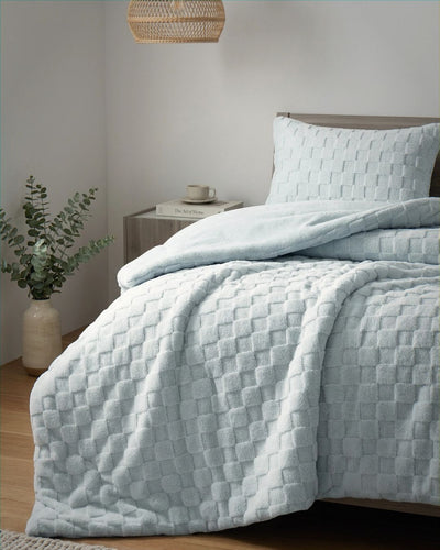 Soft blue checkered snuggle fleece comforter set styled on bed with matching pillow sham in cozy bedroom setting
